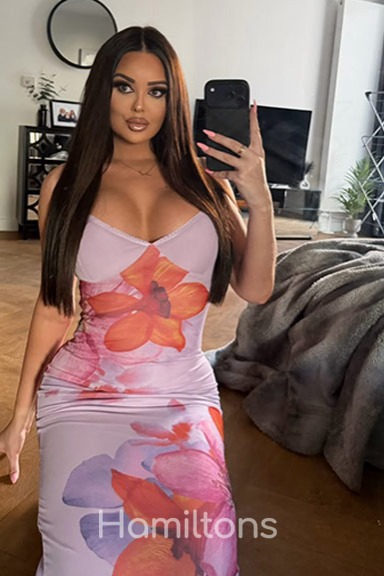 Beth in a floral print maxi dress taking a selfie